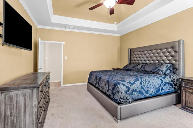 a bedroom with a bed and a flat tv screen on dresser