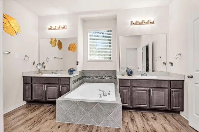 a bathroom with a tub sink and mirror