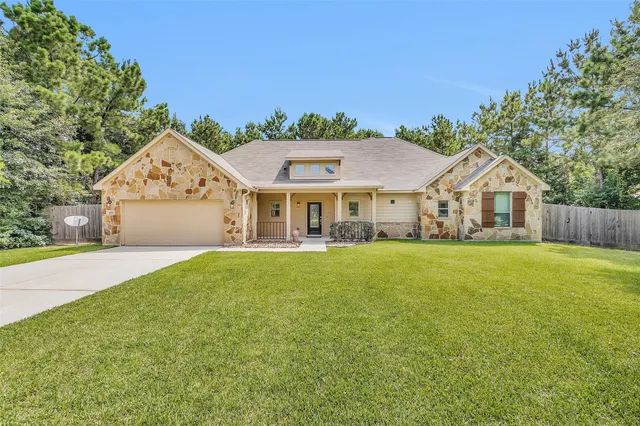 a front view of a house with yard and green space