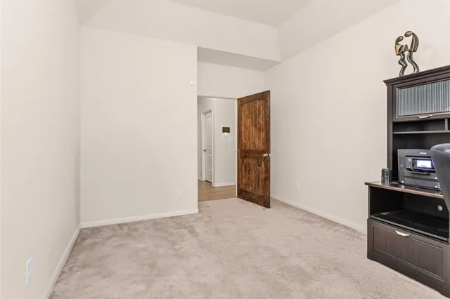 a view of an empty room with closet and a window