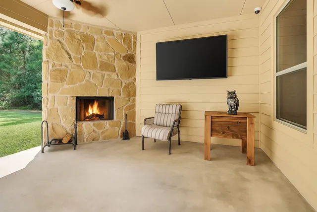 a living room with patio fireplace and a flat screen tv