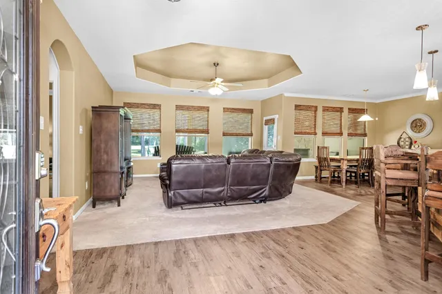 a living room with furniture a flat screen tv and a large window