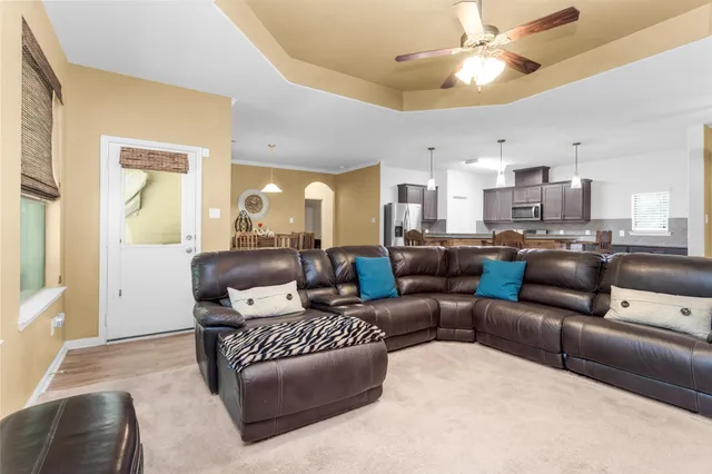 a living room with furniture kitchen and a chandelier