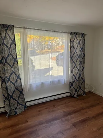 a view of a room with wooden floor and door