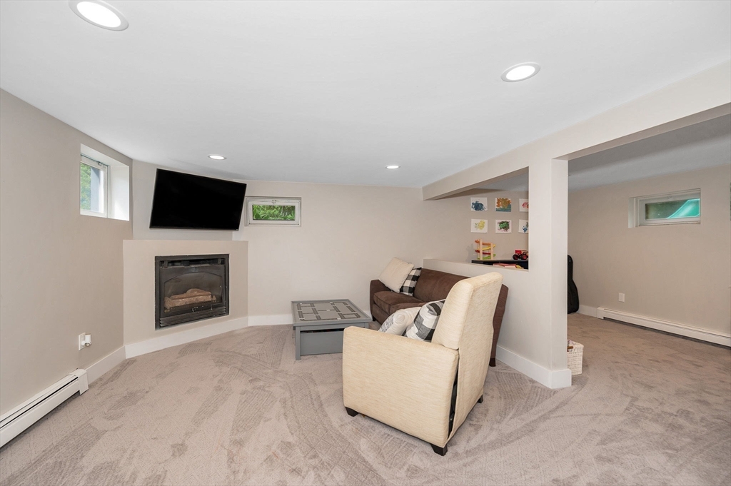 4 Governor Saltonstall Road Billerica, MA 01821 - Photo 18 of 25 a living room with furniture a fireplace and a flat screen tv