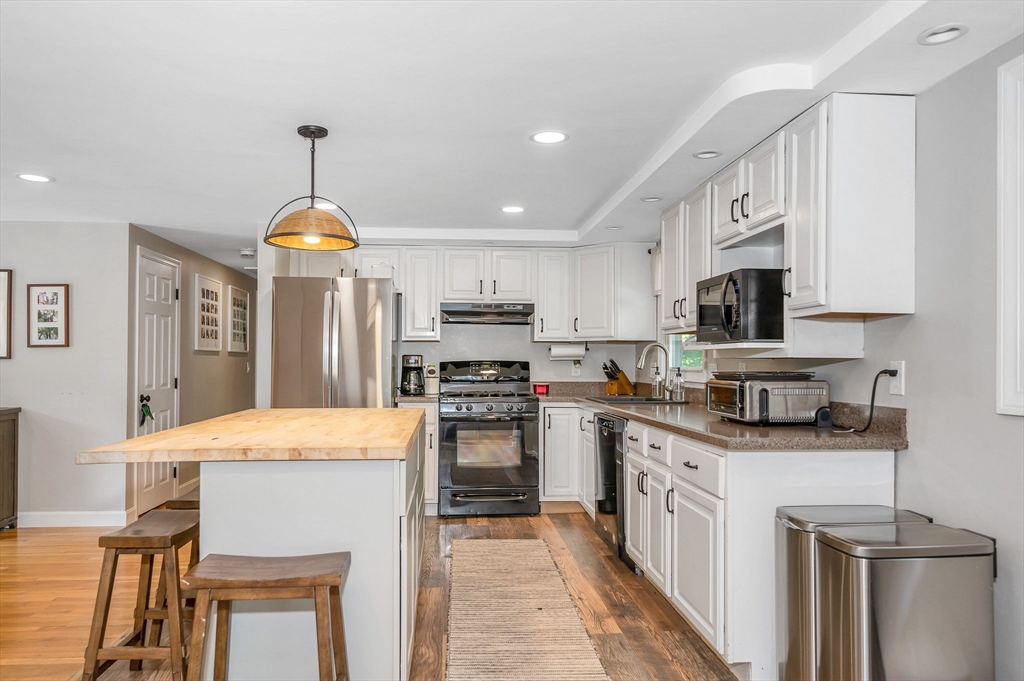 4 Governor Saltonstall Road Billerica, MA 01821 - Photo 4 of 25 a kitchen with stainless steel appliances kitchen island granite countertop a sink refrigerator stove and microwave