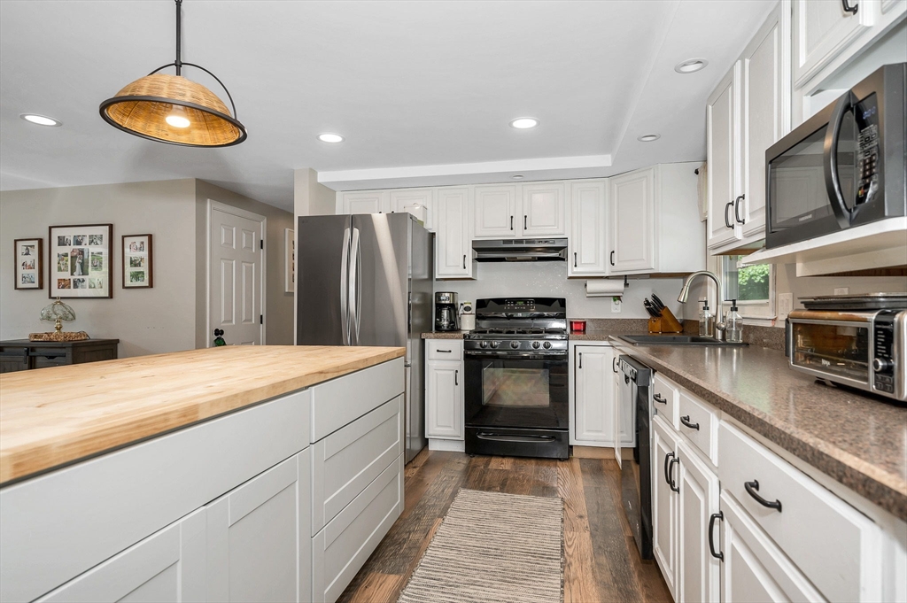 4 Governor Saltonstall Road Billerica, MA 01821 - Photo 5 of 25 a kitchen with stainless steel appliances kitchen island granite countertop a refrigerator stove and sink