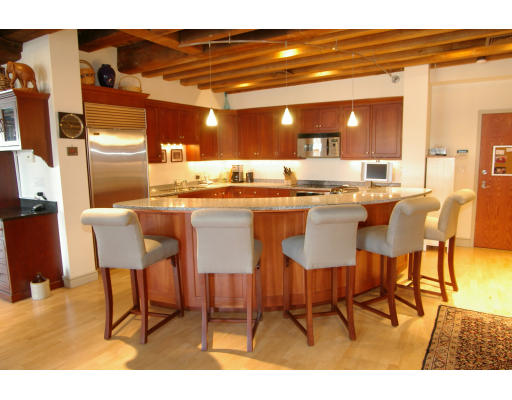 a dining area with a table chairs and a kitchen view
