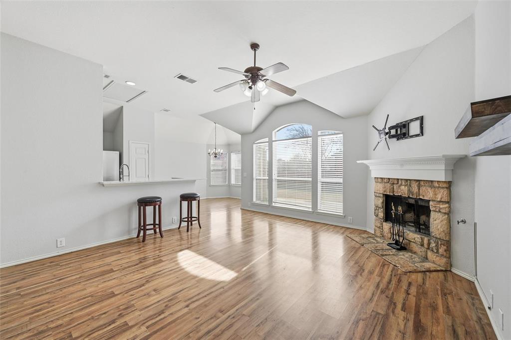 1020 Hay Stack Court Little Elm, TX 75068 - Photo 2 of 20 a view of a livingroom with furniture a fireplace wooden floor and chandelier