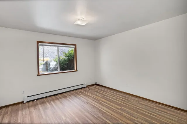 a view of empty room with wooden floor
