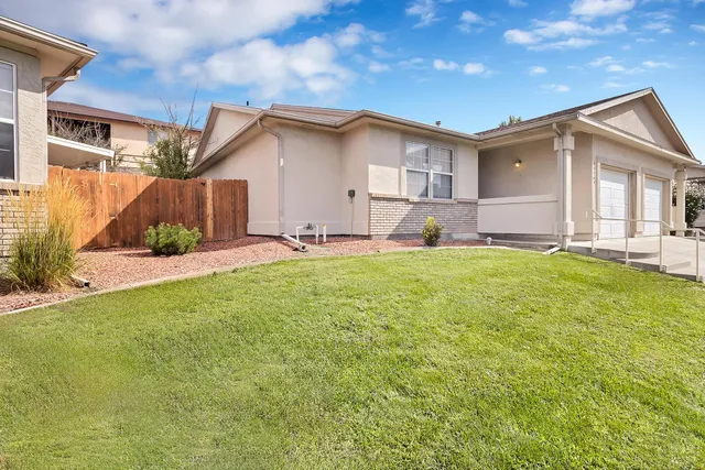 a view of a house with a yard and pathway