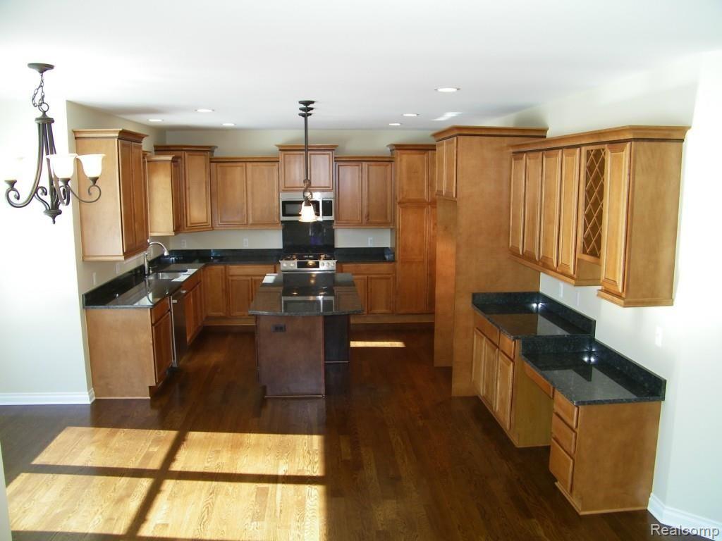 5415 Inverrary Lane Commerce Township, MI 48382 - Photo 10 of 18 GOURMET KITCHEN FEATURES GRANITE COUNTERTOPS, STAINLESS STEEL BOSCH APPLIANCES, STAINLESS STEEL SINK, MERILLAT CABINETS, HARDWOOD FLOORS, ELEGANT PENDANT LIGHTING AND OVERHEAD LIGHTING.