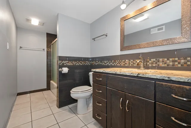 a bathroom with a sink a toilet and mirror