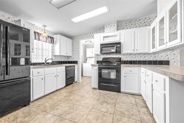 a kitchen with stainless steel appliances granite countertop a stove top oven a sink dishwasher and a refrigerator