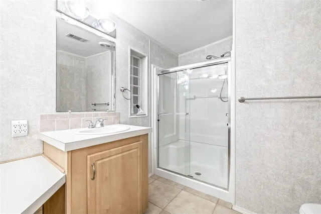 a bathroom with a shower sink and mirror