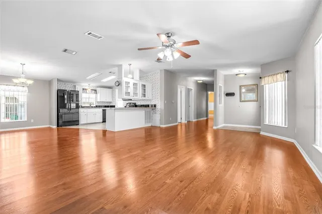 a view of a kitchen with a dishwasher a kitchen island with wooden floor and a large window