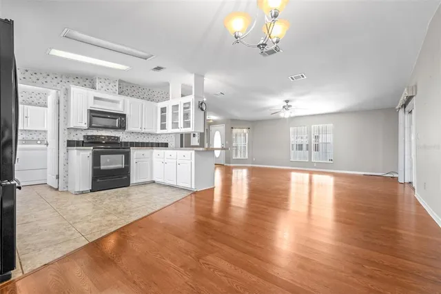 a view of kitchen with microwave a stove and wooden floor