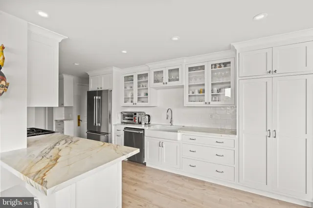 a kitchen with white cabinets and window