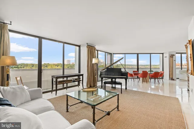 a living room with furniture and floor to ceiling windows