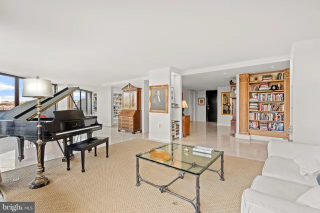 a living room with furniture a piano and a potted plant