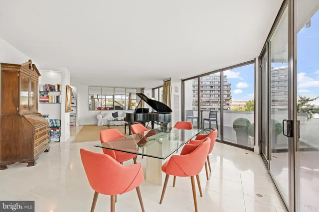 a dining room with furniture and a floor to ceiling window