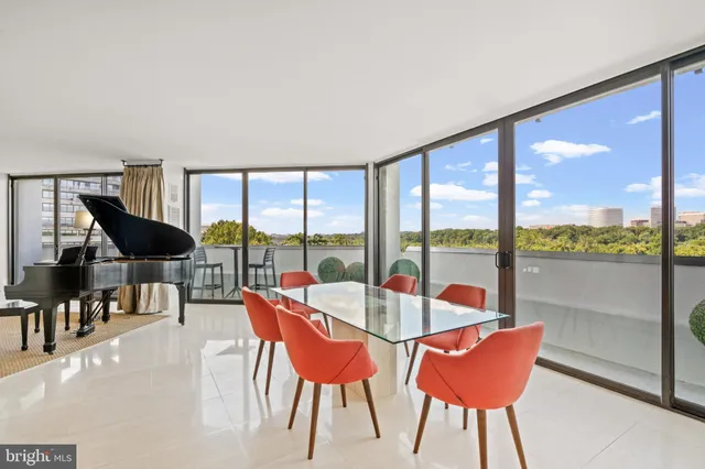 a dining room with furniture water view and a floor to ceiling window