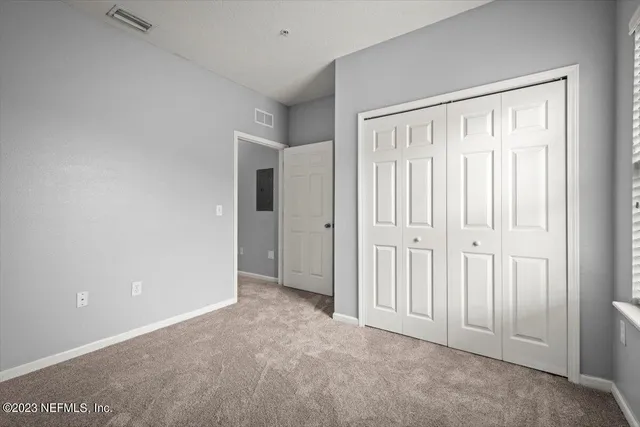 an empty room with windows and closet