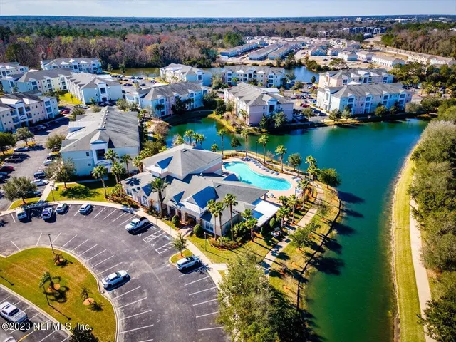 an aerial view of a house with a garden and lake view