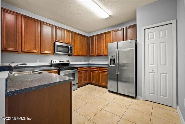 a kitchen with granite countertop cabinets stainless steel appliances and a sink