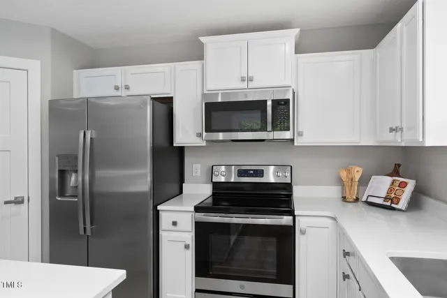 a kitchen with stainless steel appliances a sink a stove a microwave and cabinets