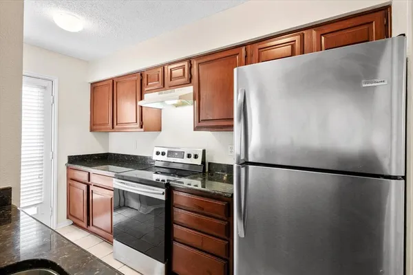 a kitchen with stainless steel appliances granite countertop a refrigerator and a stove