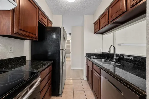 a kitchen with stainless steel appliances granite countertop a sink stove and cabinets