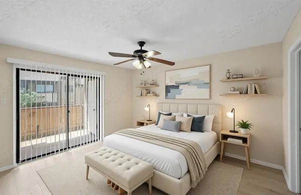 a bedroom with a large bed and a chandelier fan