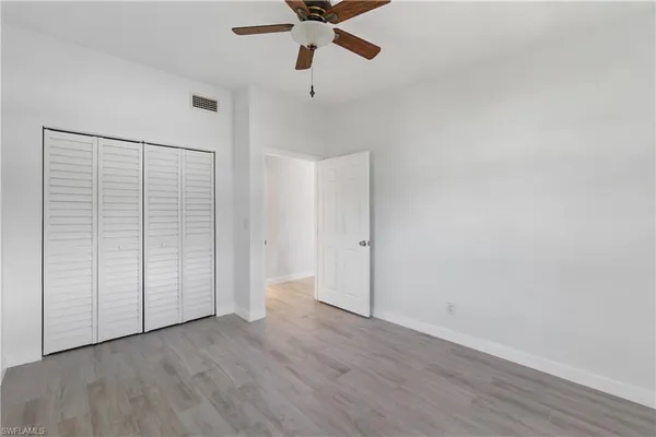 an empty room with a window and a fan