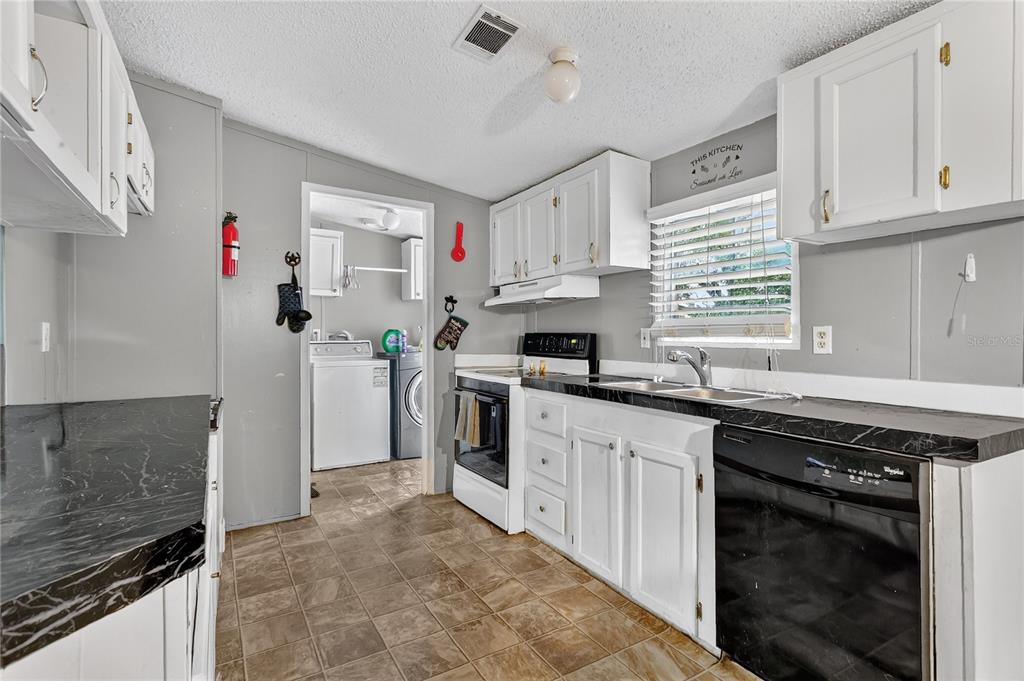 42312 Webster Street Altoona, FL 32702 - Photo 9 of 30 a kitchen with granite countertop a sink stainless steel appliances and cabinets