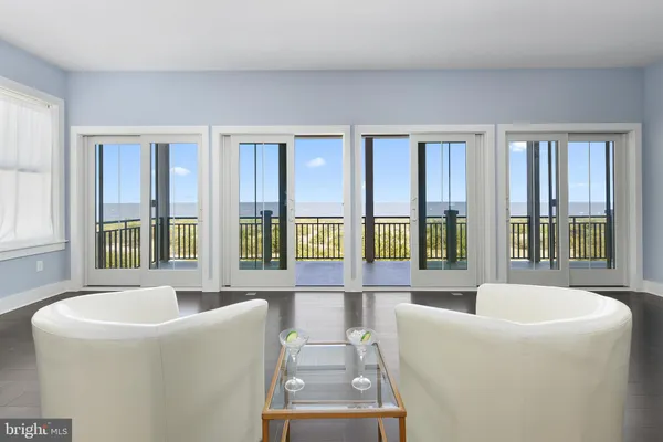 a living room with furniture and large windows
