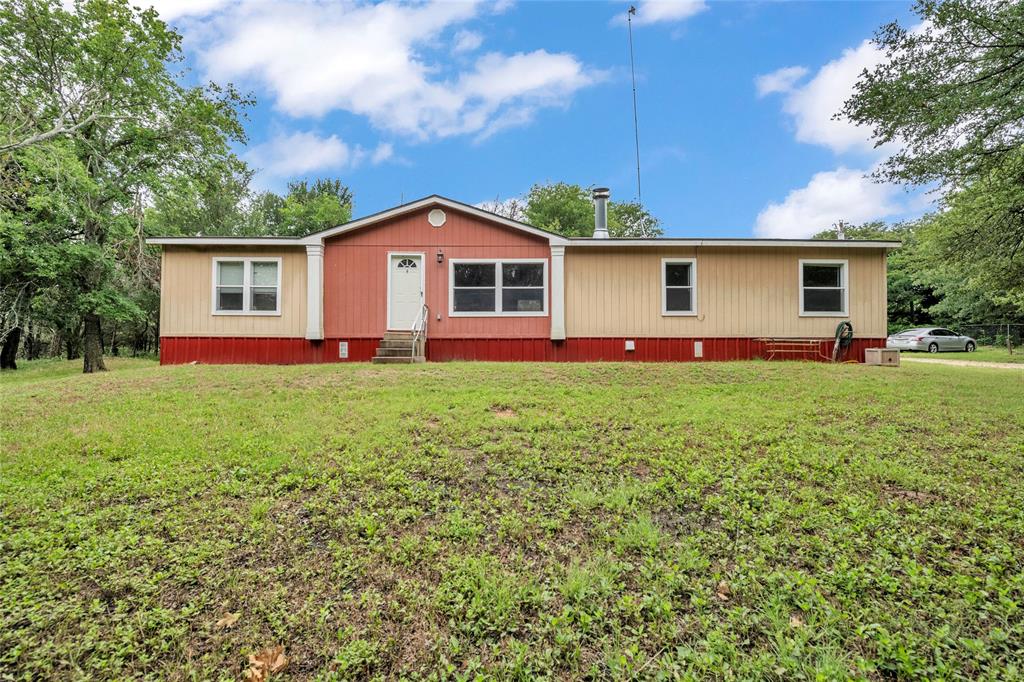 a front view of house with yard and green space