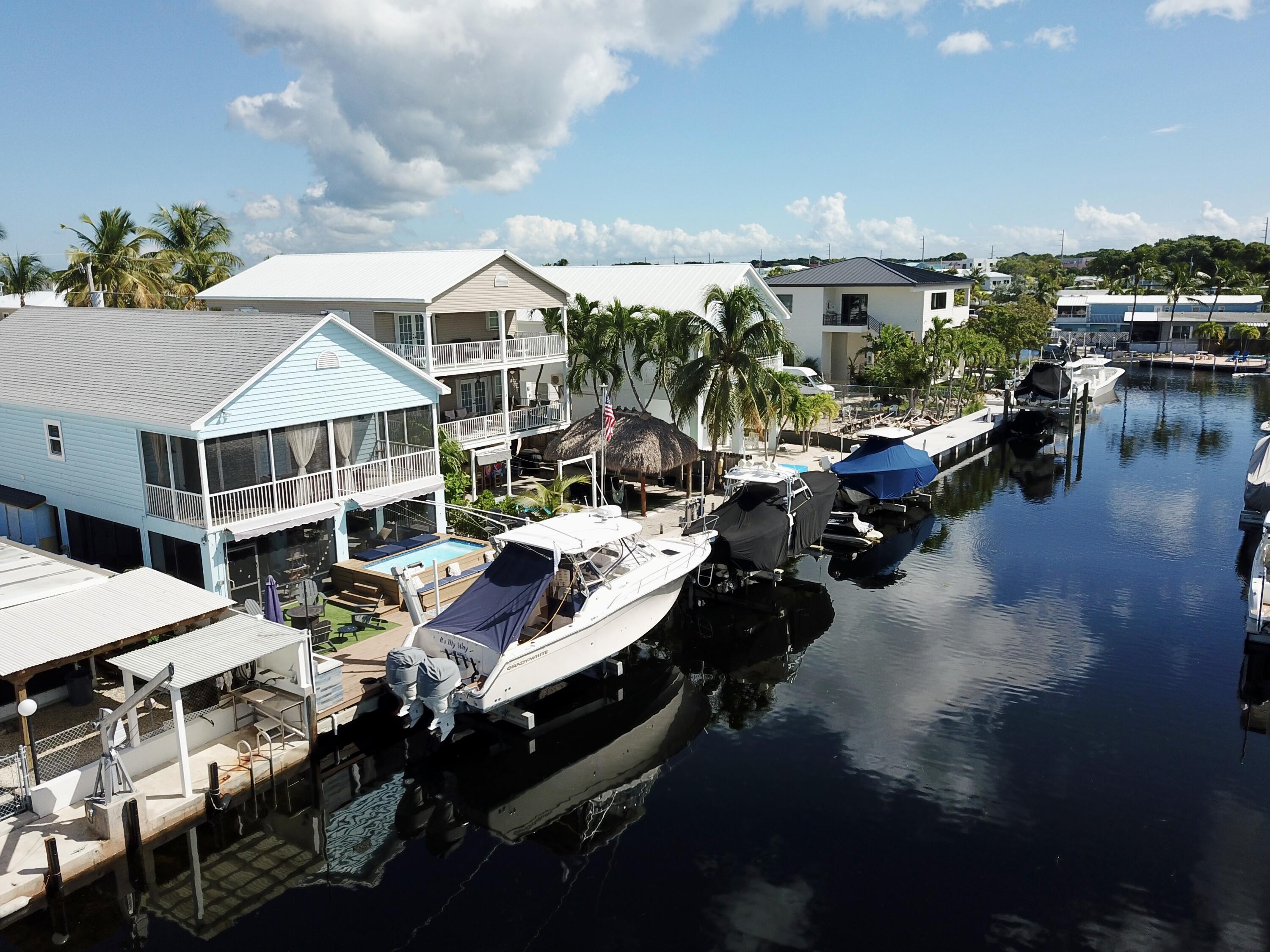 614 R Santa Anita Lane Key Largo, FL 33037 - Photo 3 of 64 a roof deck with table and chairs a barbeque with potted plants