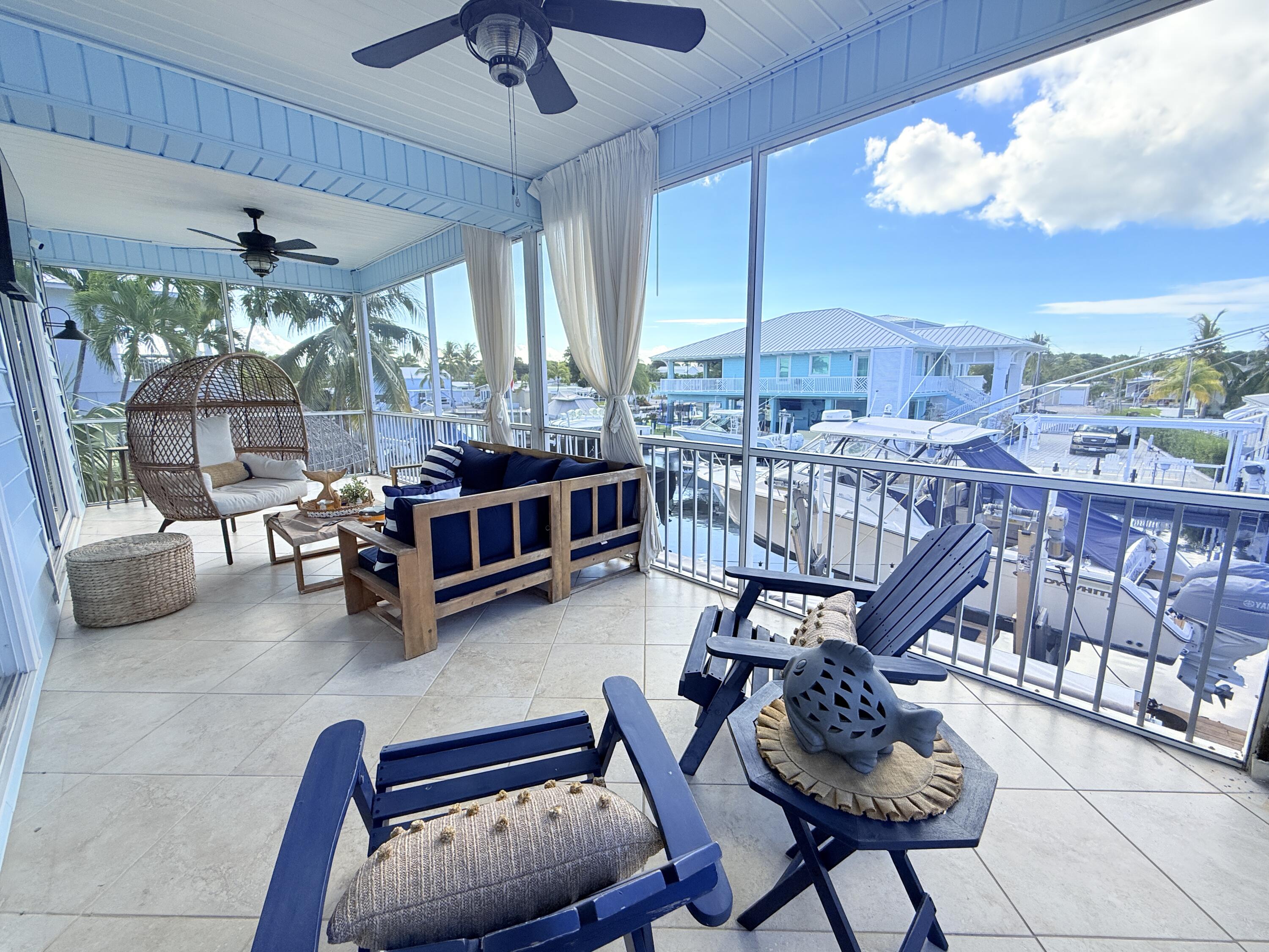 614 R Santa Anita Lane Key Largo, FL 33037 - Photo 34 of 64 a living room with furniture a chandelier and a floor to ceiling window