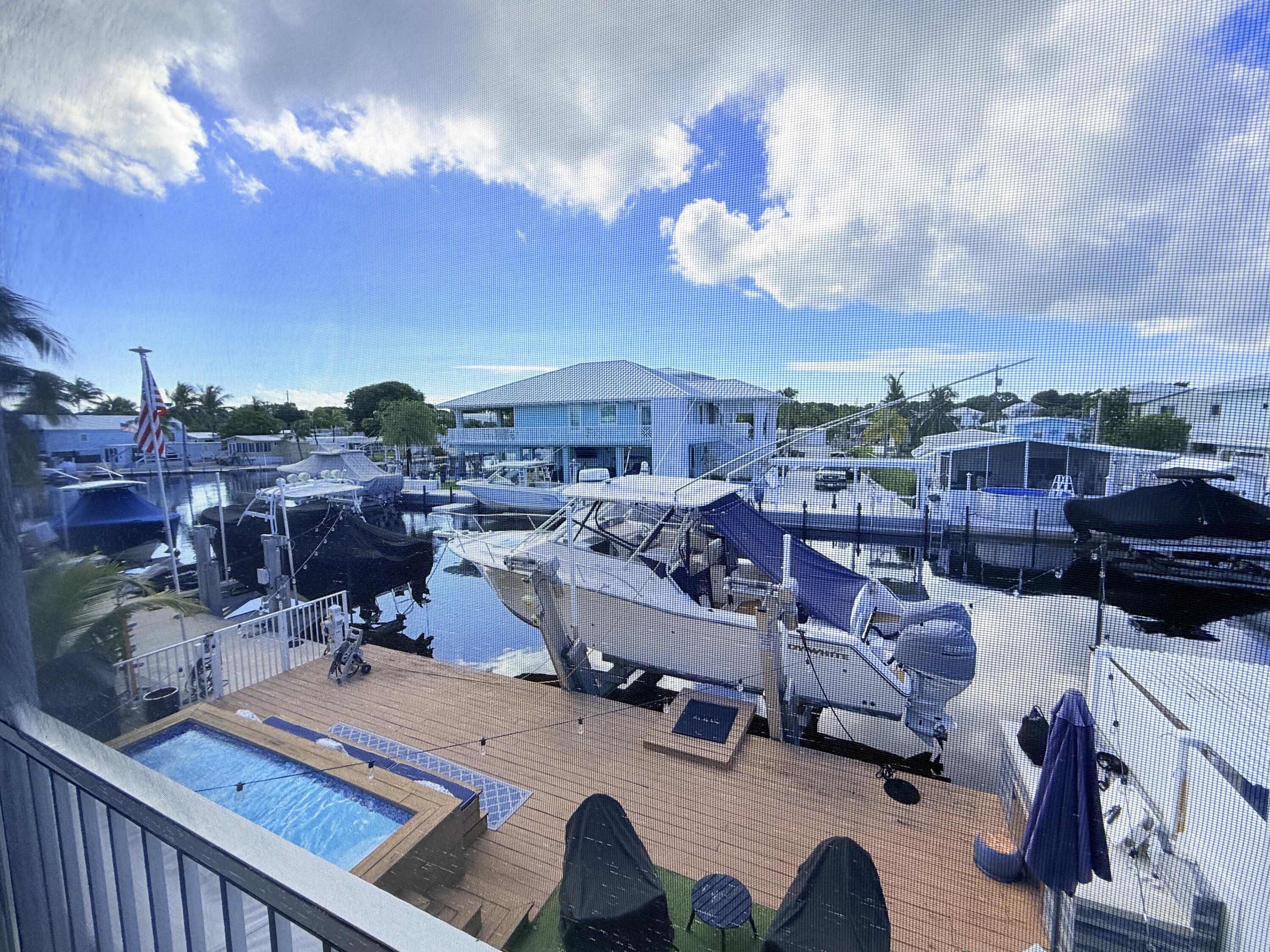 614 R Santa Anita Lane Key Largo, FL 33037 - Photo 38 of 64 a view of a roof deck with table and chairs with wooden floor and fence