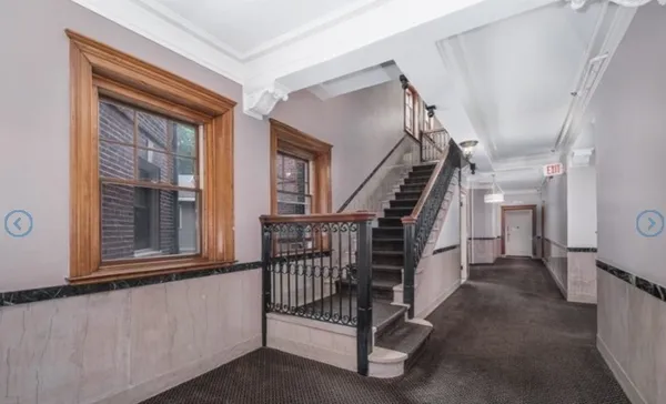 a view of staircase with lots of frames on wall and stairs