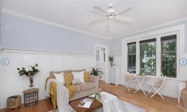 a living room with furniture a ceiling fan and a window