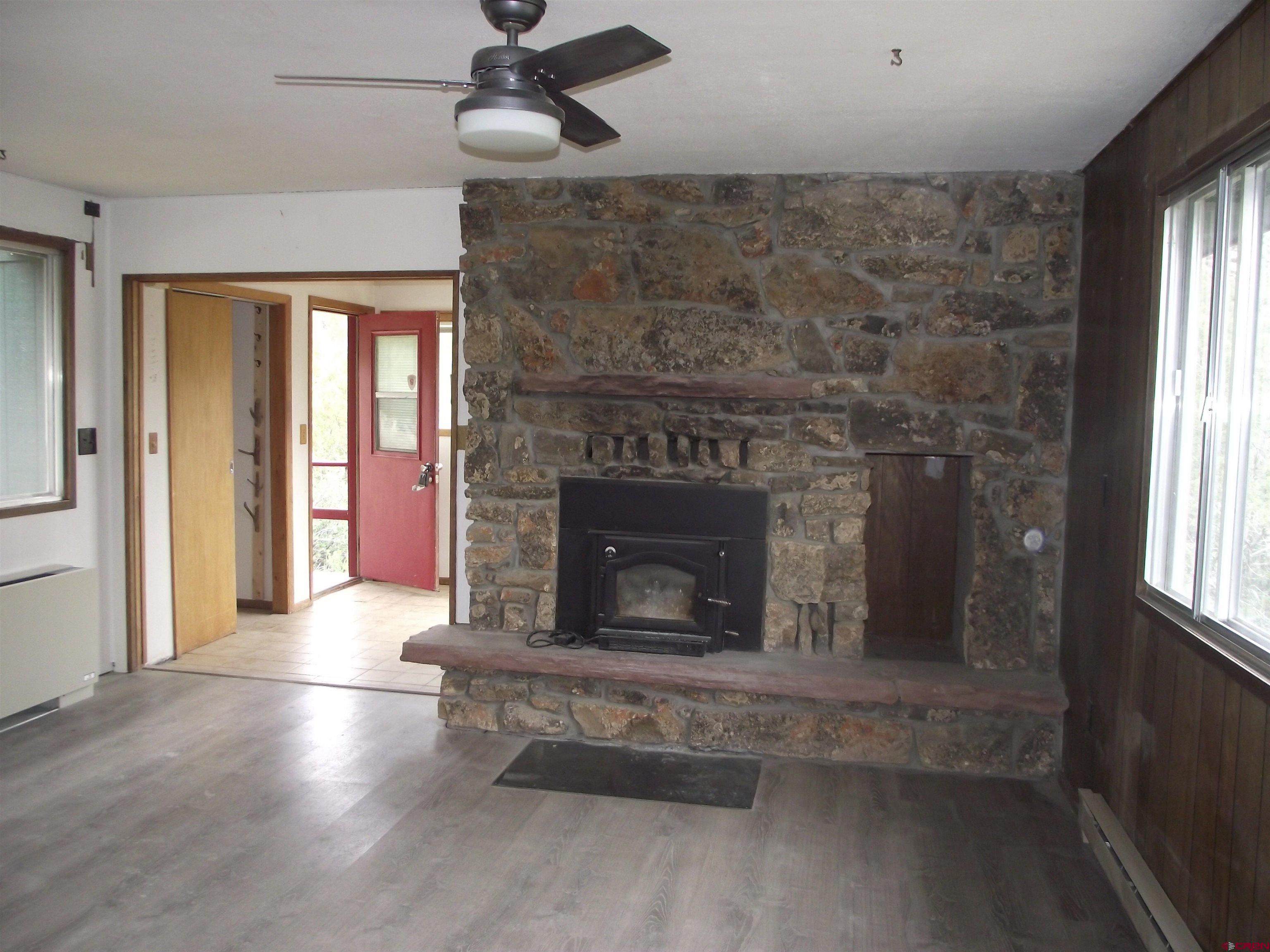42996 Needle Rock Road Crawford, CO 81415 - Photo 21 of 45 an empty room with windows and fireplace