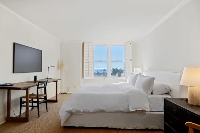 a bedroom with a bed a table and chair