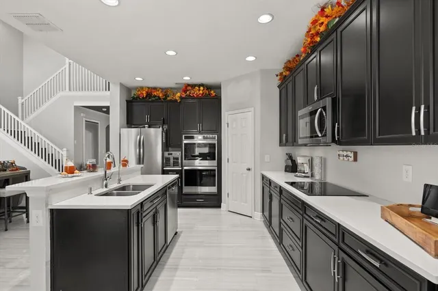 a kitchen with stainless steel appliances a sink stove top oven and cabinets