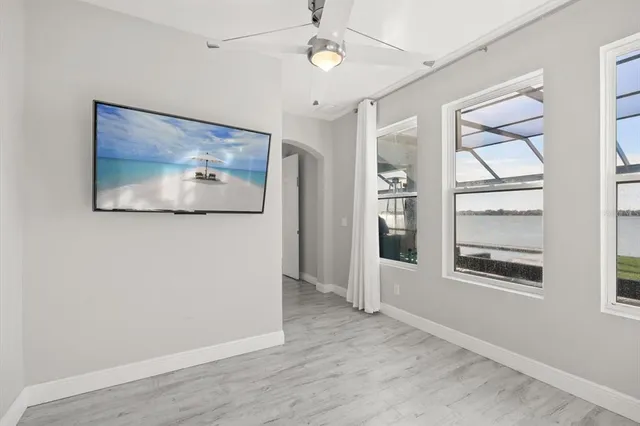 a view of an empty room with window and wooden floor