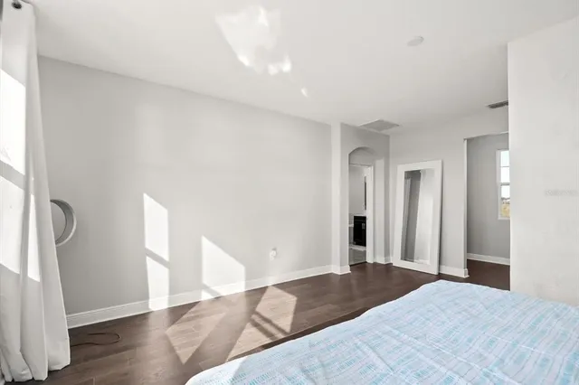 a view of a bedroom with wooden floor and a window