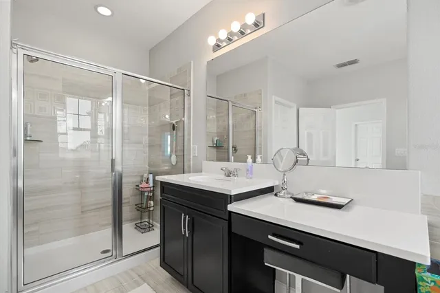 a bathroom with a shower sink and mirror
