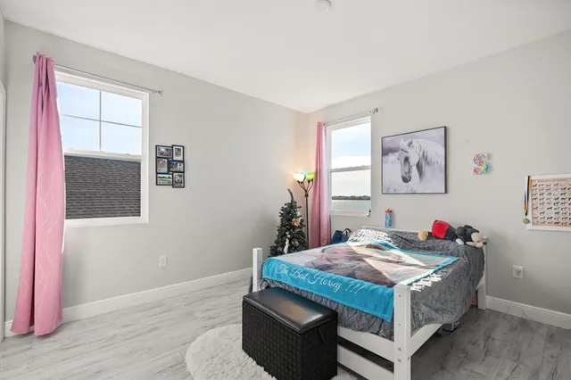 a bedroom with a bed and a dresser next to a window