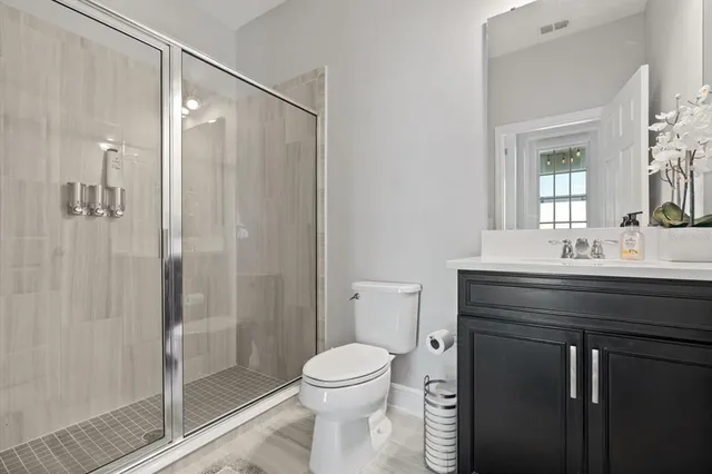 a bathroom with a sink a toilet and shower